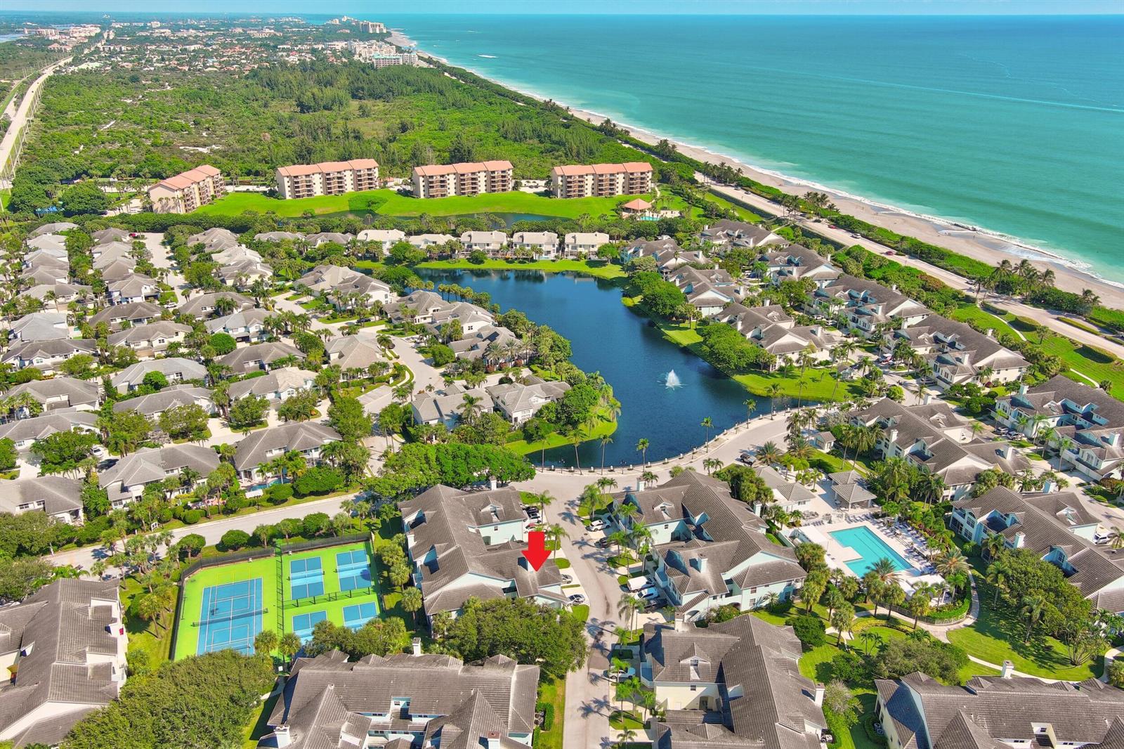 An aerial view shows a coastal residential community with a lake, tennis courts, and pool — 1701 Mizzenmast Way, Jupiter FL 33477, JUPITER, FL
