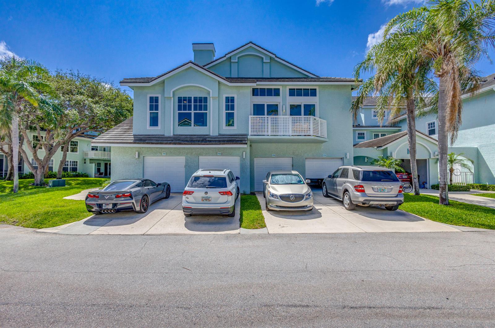A light green multi-unit residential building with four garage doors and four parked cars — 1701 Mizzenmast Way, Jupiter FL 33477, JUPITER, FL
