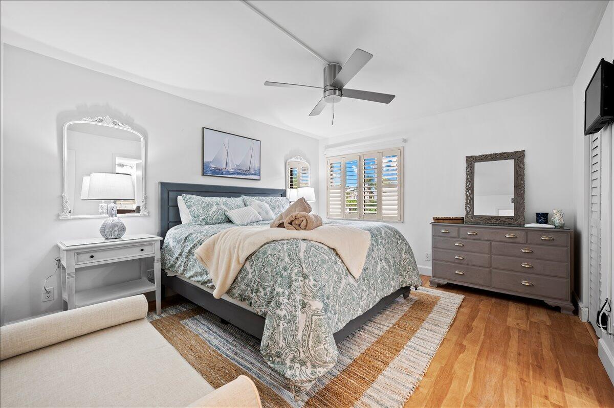 A bedroom features a bed with patterned bedding, a grey dresser, and a ceiling fan — 1605 S Us Highway 1 # A303, Jupiter FL 33477, JUPITER, FL