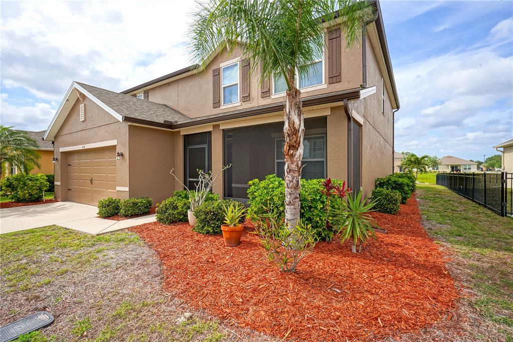 A two-story house with a tan stucco exterior, a screened-in porch, and a palm tree — 436 GREAT FALLS LANE SW, PALM BAY, FL
