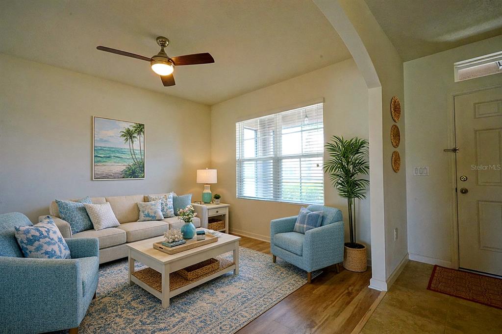 A living room features a sofa, two armchairs, a coffee table, and a ceiling fan — 436 GREAT FALLS LANE SW, PALM BAY, FL