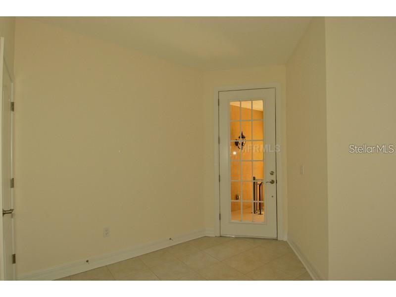 A room with light-colored walls, tile flooring, and a white door with glass panes — 6404 MARGARITA SHORES LANE, APOLLO BEACH, FL