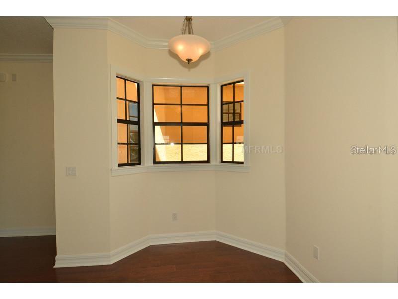 A dining nook with a bay window, hardwood floors, and a hanging light fixture — 6404 MARGARITA SHORES LANE, APOLLO BEACH, FL