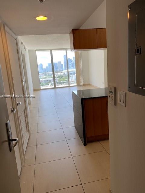 An interior view of a condo entrance leading to a kitchen island and a balcony view — 1750 N Bayshore Dr # 2806, Miami FL 33132, MIAMI, FL