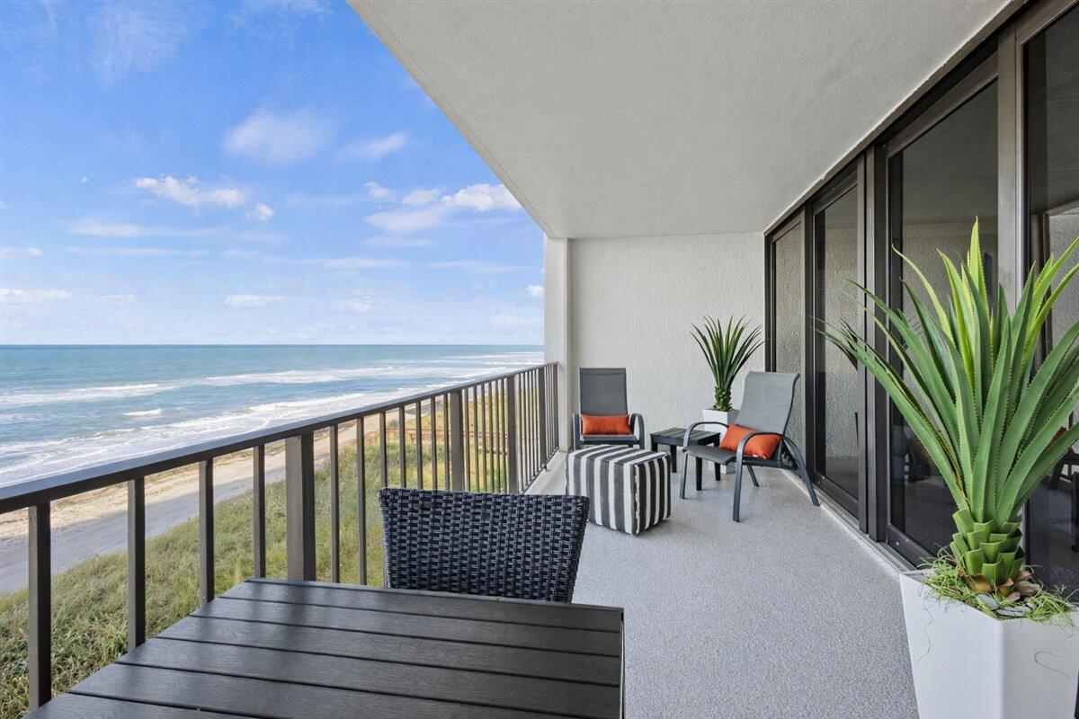 A balcony with outdoor furniture overlooks the ocean under a blue sky — 8750 S Ocean Drive # 334, Jensen Beach FL 34957, JENSEN BEACH, FL