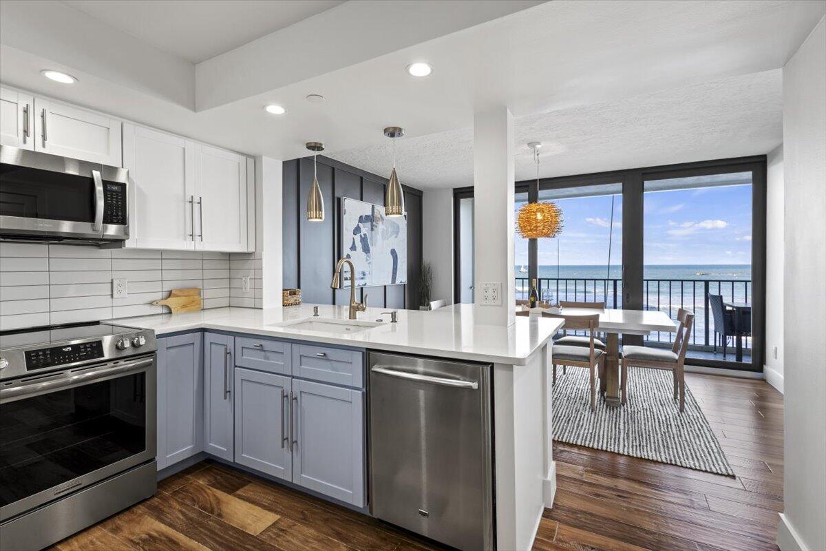 A modern kitchen with light blue cabinets, white countertops, and a view of the ocean — 8750 S Ocean Drive # 334, Jensen Beach FL 34957, JENSEN BEACH, FL