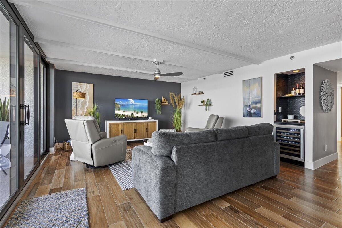 A living room features a gray sofa, a recliner, a television, and a wet bar — 8750 S Ocean Drive # 334, Jensen Beach FL 34957, JENSEN BEACH, FL
