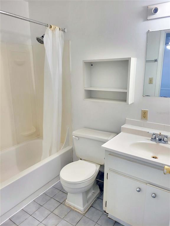 A bathroom features a white vanity, a toilet, and a shower-tub combination with a curtain — 914 SW 8TH AVENUE UNIT 26, GAINESVILLE, FL
