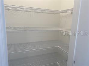 A walk-in pantry features white wire shelving installed on three walls — 1738 FOREMAN ROAD, EAGLE LAKE, FL