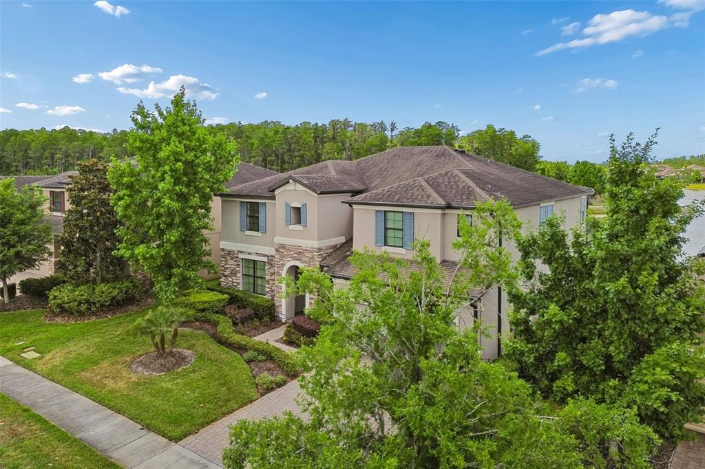 An aerial view of a two-story suburban house with stone accents and a paved driveway — 13218 BATTEN LANE, ODESSA, FL