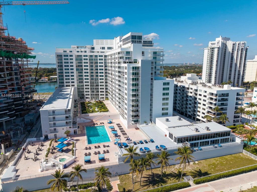 An aerial view shows a large white apartment complex with a pool deck and courtyard — 5401 Collins Ave # 919, Miami Beach FL 33140, MIAMI BEACH, FL