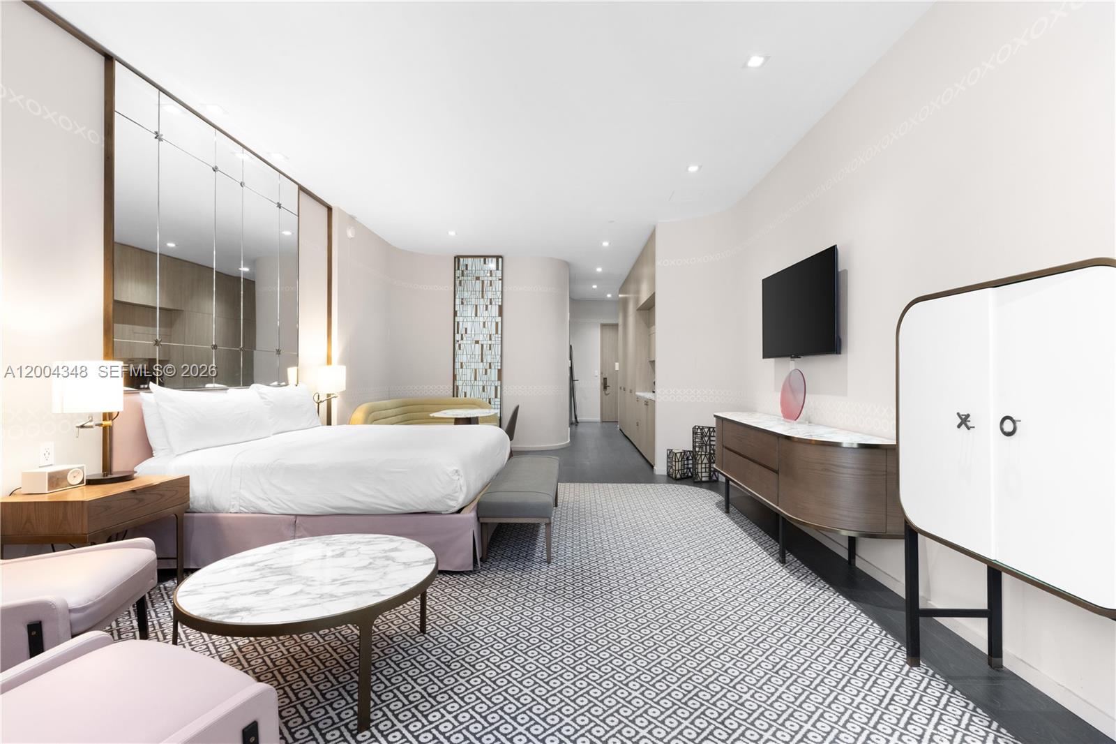 A modern hotel bedroom features a king bed, a marble coffee table, and patterned carpeting — 801 Miami Ave # 709, Miami FL 33130, MIAMI, FL