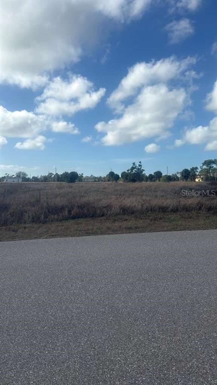 A view of a vacant, grassy lot from an adjacent paved road — 53 LATEEN SAIL DRIVE, PLACIDA, FL