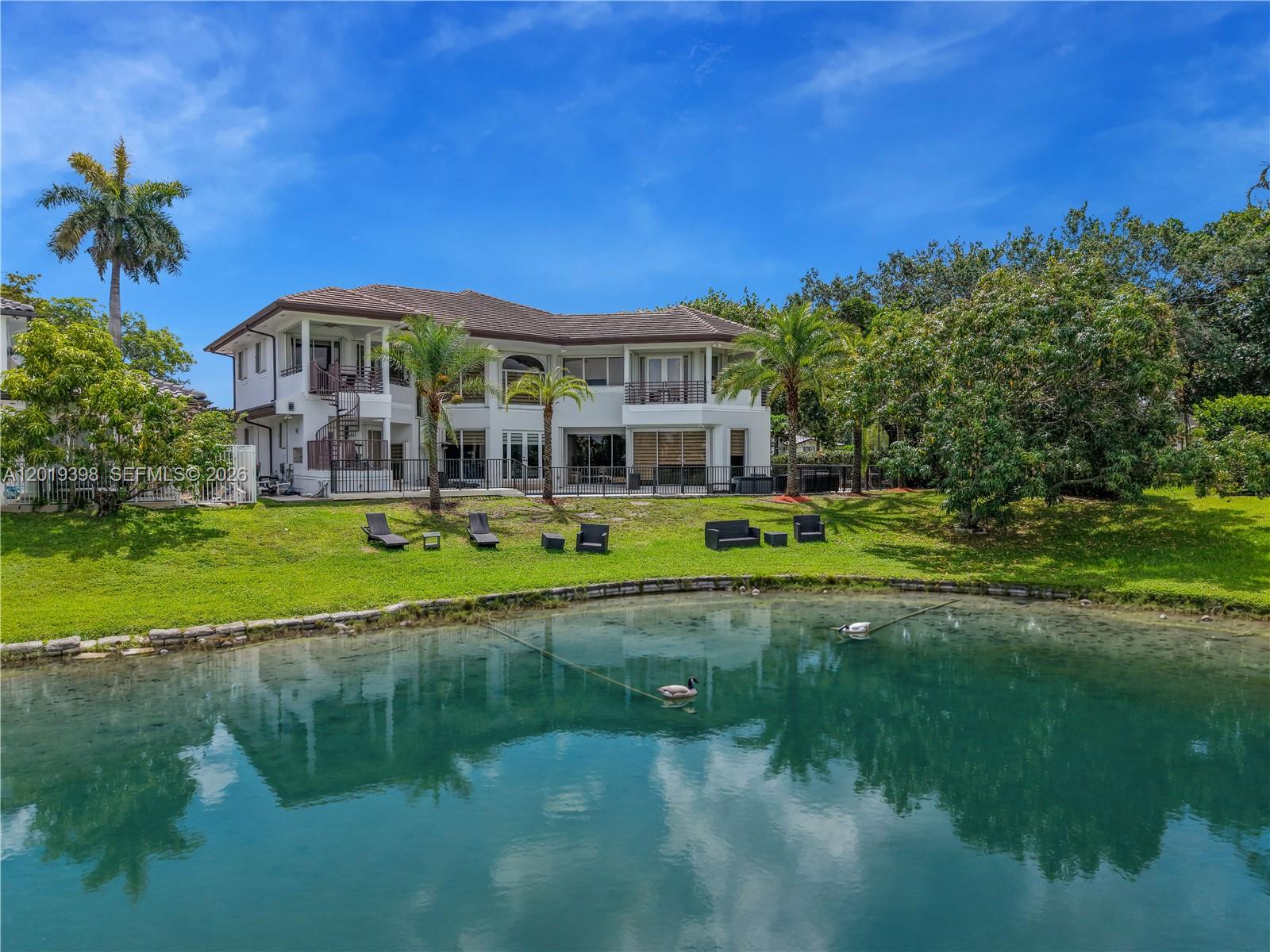 A two-story house with a spiral staircase overlooks a pond with two ducks — 14332 Ardoch Pl, Miami Lakes FL 33016, MIAMI LAKES, FL