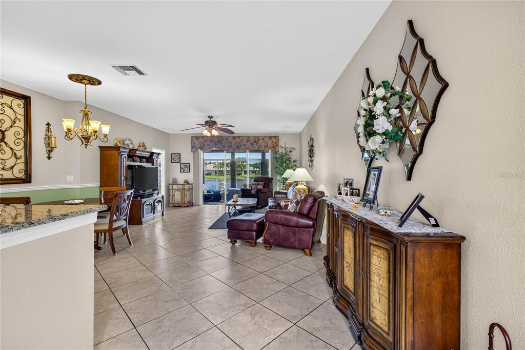 A living and dining area features tile floors, a wooden sideboard, and a lake view — 16141 AMETHYST KEY DRIVE, WIMAUMA, FL