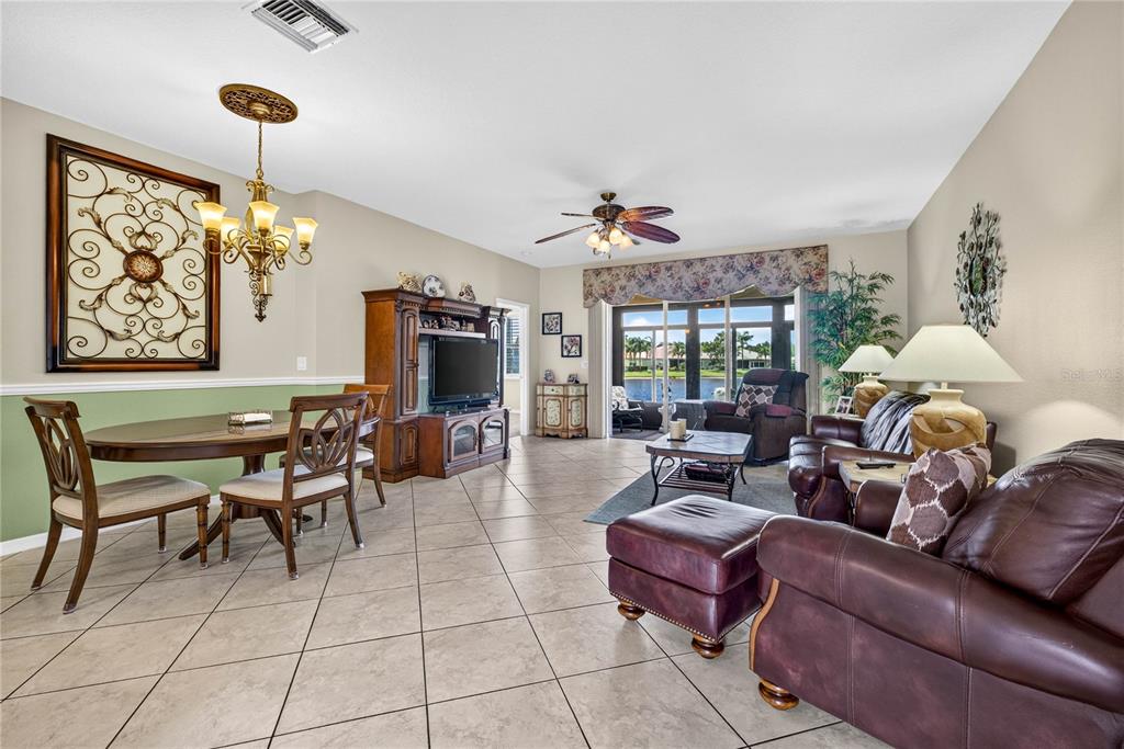 A combined dining and living room features tile floors, a ceiling fan, and sliding glass doors — 16141 AMETHYST KEY DRIVE, WIMAUMA, FL
