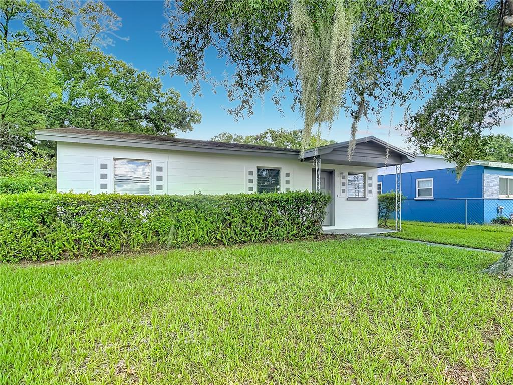 A white single-story house with a front hedge and a covered entryway — 1025 S CENTRAL AVENUE, LAKELAND, FL
