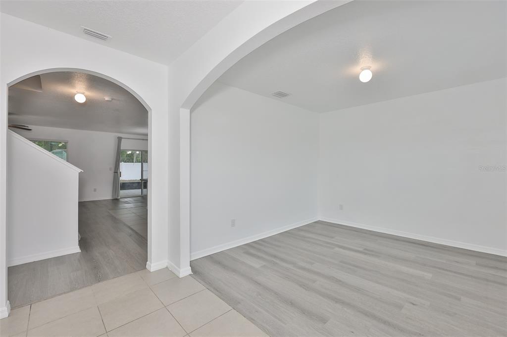 A covered patio features a tiled floor, two ceiling fans, and a wooden wet bar — 5461 MAGDALENE WAY, ZEPHYRHILLS, FL