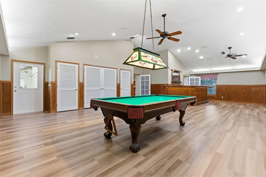 A spacious game room features a pool table, a wooden bar, and wood-paneled walls — 3612 SUGAR LOAF LANE, VALRICO, FL