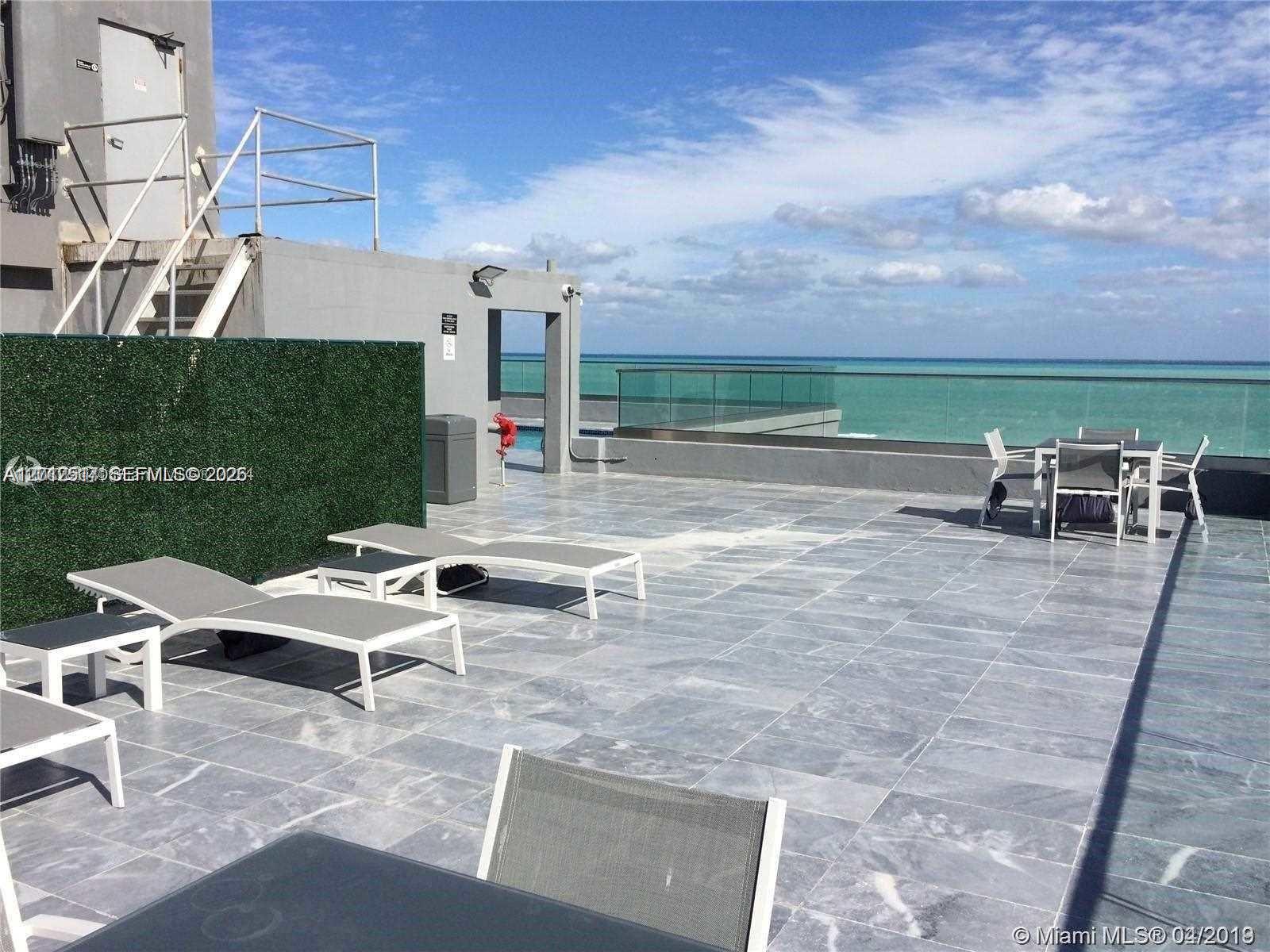 A rooftop terrace features gray tile flooring, lounge chairs, a dining set, and ocean views — 1255 Collins Ave # 507, Miami Beach FL 33139, MIAMI BEACH, FL
