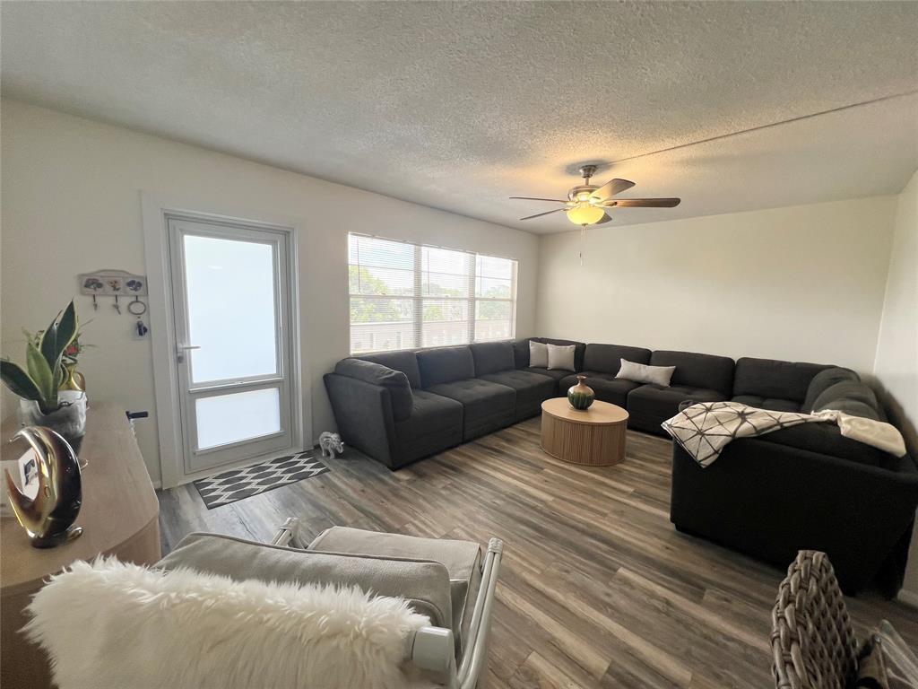 A living room features a large gray sectional sofa, wood-look flooring, and a ceiling fan — 410 Grantham A # 410, Deerfield Beach FL 33442, DEERFIELD BEACH, FL