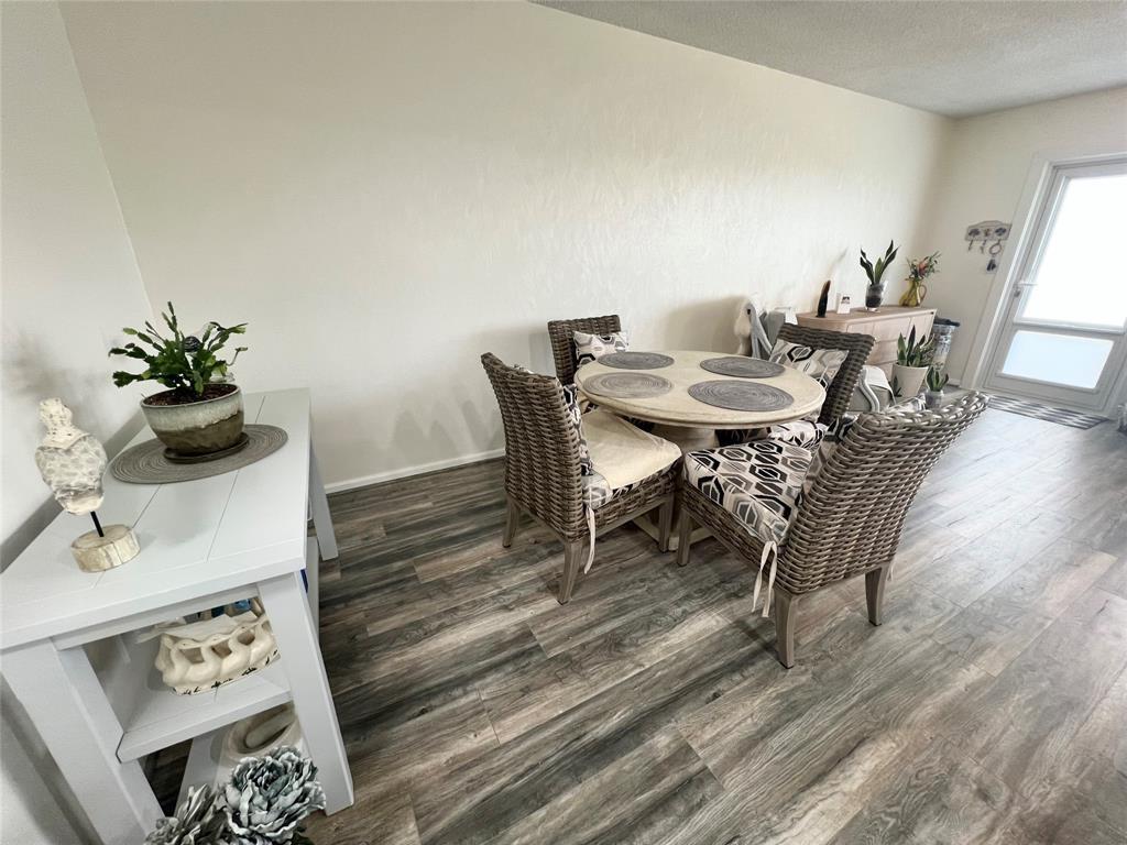A dining area features a round table with four wicker chairs on wood-look flooring — 410 Grantham A # 410, Deerfield Beach FL 33442, DEERFIELD BEACH, FL