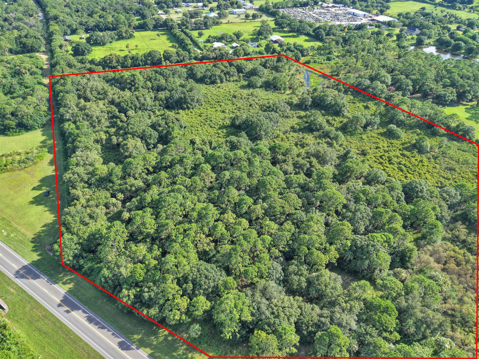 An aerial view shows a large, wooded rectangular plot of land bordered by a road — 100 NW 38th Avenue, Okeechobee FL 34972, OKEECHOBEE, FL