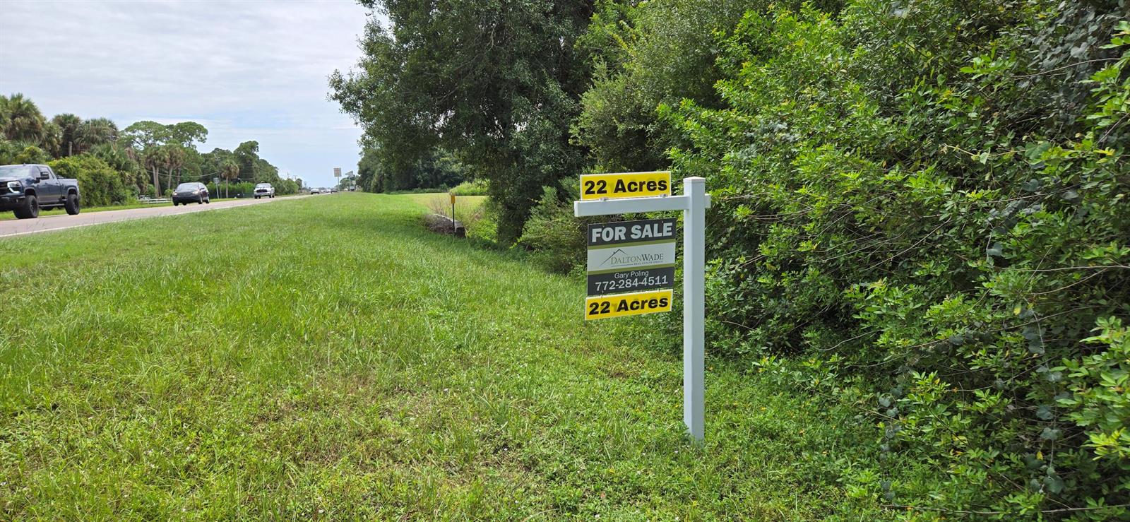 A for sale sign for 22 acres stands in a grassy field beside a road — 100 NW 38th Avenue, Okeechobee FL 34972, OKEECHOBEE, FL