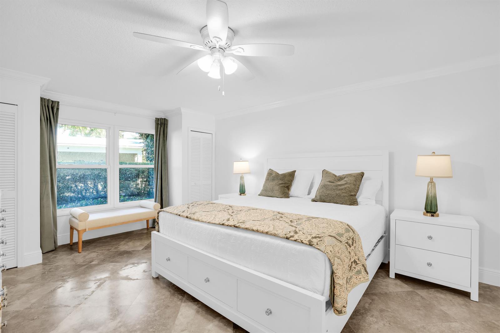 A bedroom features a white bed with a patterned runner, two nightstands, and tile flooring — 4161 U.s. Hwy 1 # I2, Jupiter FL 33477, JUPITER, FL