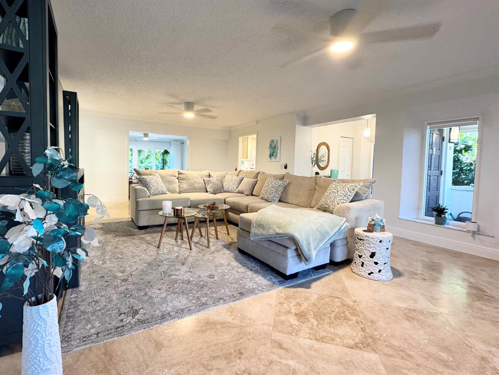 A living room features a large sectional sofa, a patterned area rug, and tile flooring — 4161 U.s. Hwy 1 # I2, Jupiter FL 33477, JUPITER, FL