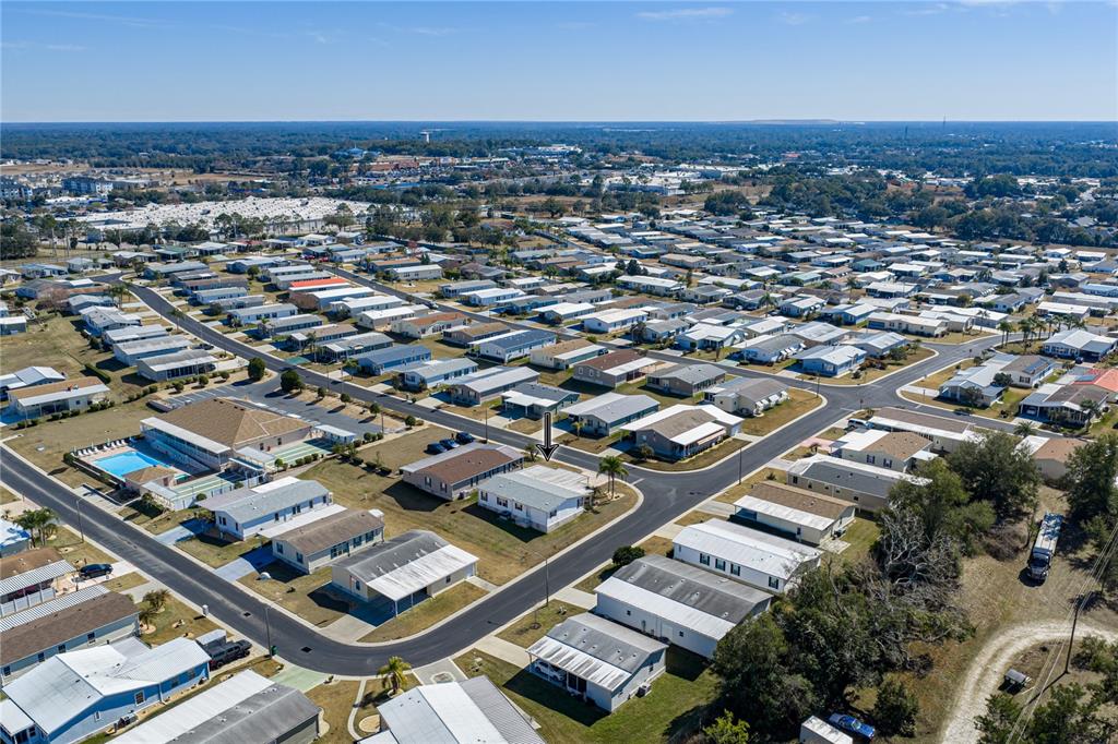 An aerial view shows a residential neighborhood with many manufactured homes and a community pool — 37519 COREY LEWIS AVENUE, ZEPHYRHILLS, FL