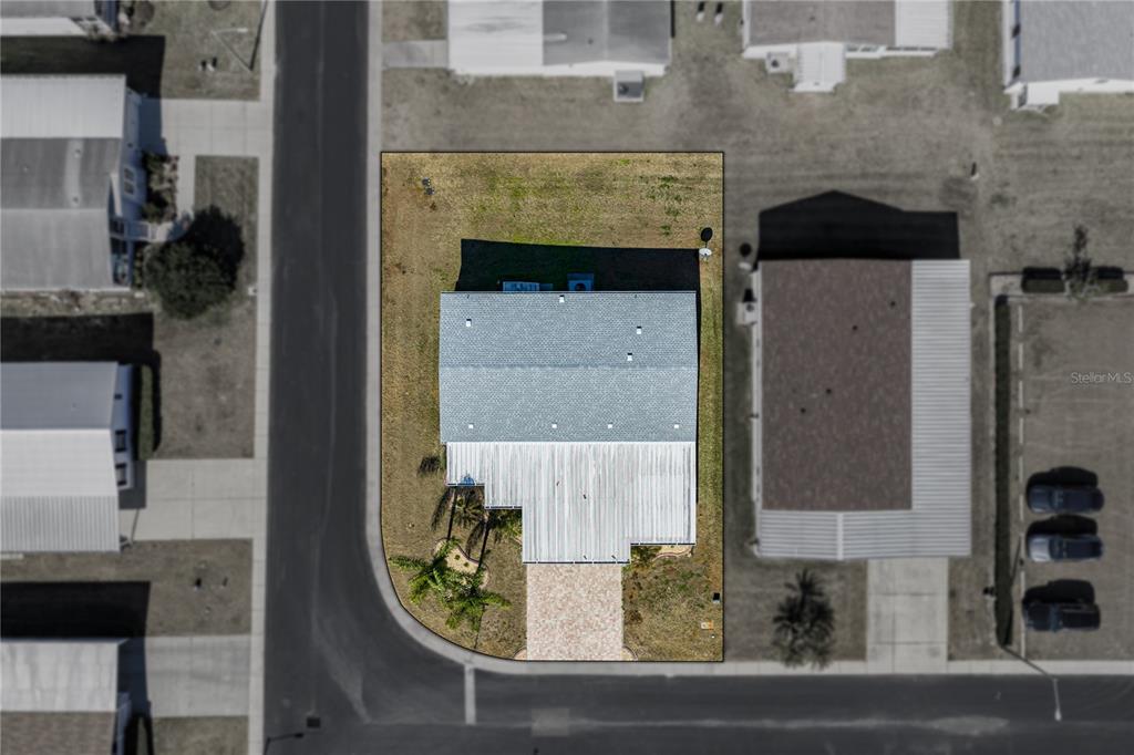 An aerial view shows a house with a paved driveway on a corner lot — 37519 COREY LEWIS AVENUE, ZEPHYRHILLS, FL