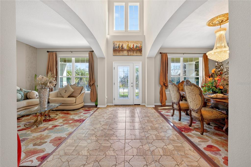 A tiled entryway leads to a living room and dining room with high arched ceilings — 882 COUNTS CREST CIRCLE, APOPKA, FL