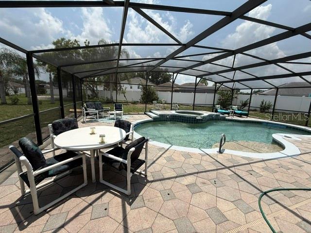 A screened-in patio features a swimming pool with an attached spa and paver decking — 4914 NEWTON COURT, ST CLOUD, FL