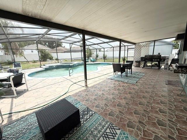 A screened-in patio features outdoor furniture on a patterned rug and a paved floor — 4914 NEWTON COURT, ST CLOUD, FL