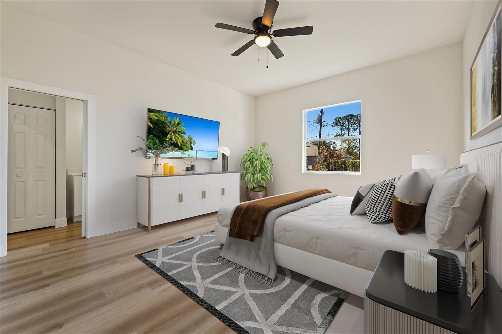 A bedroom features a bed, a television on a white console, and a ceiling fan — 774 Cleaves Street, Palm Bay FL 32909, PALM BAY, FL