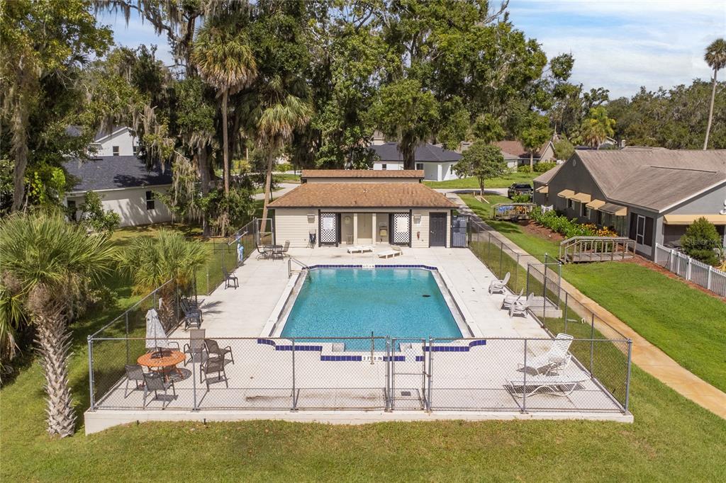An aerial view of a rectangular swimming pool enclosed by a chain-link fence — 947 BELLE OAK DRIVE, LEESBURG, FL