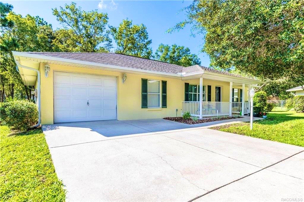 A yellow single-story house with a white garage door and a front porch — 996 W COLBERT COURT, BEVERLY HILLS, FL