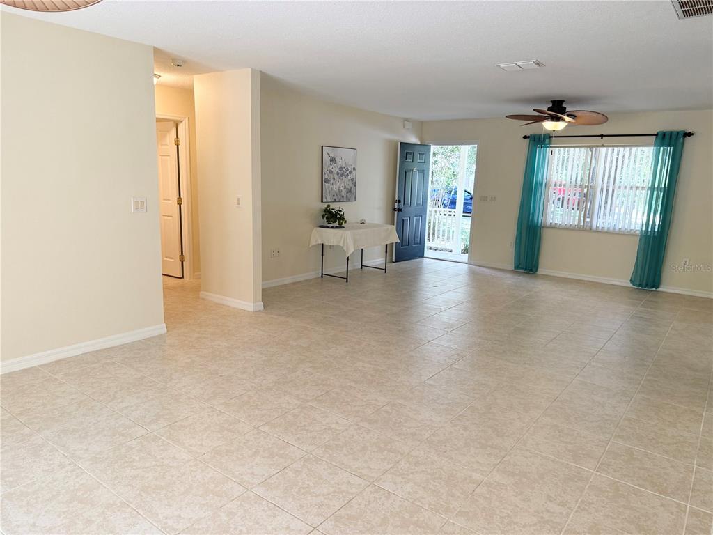 An open living area features tile flooring, a ceiling fan, and an open front door — 996 W COLBERT COURT, BEVERLY HILLS, FL