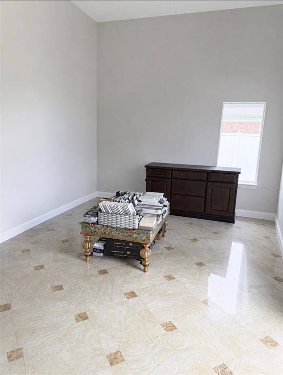 A room with light-colored tile flooring, a dark wood cabinet, and a central display table — 1730 S US HIGHWAY 27, CLERMONT, FL