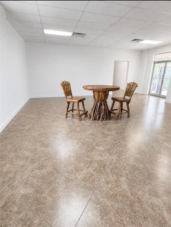 A sparse room features a rustic wooden table and two chairs on tiled flooring — 1730 S US HIGHWAY 27, CLERMONT, FL