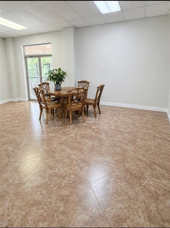 A dining set with four wooden chairs sits on a tiled floor in a room — 1730 S US HIGHWAY 27, CLERMONT, FL