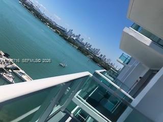 A high-angle view from a balcony overlooking a bay with boats and a city skyline — 1000 West Ave # 1427, Miami Beach FL 33139, MIAMI BEACH, FL