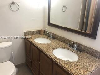 A bathroom features a double vanity with a granite countertop and a large wall mirror — 1000 West Ave # 1427, Miami Beach FL 33139, MIAMI BEACH, FL