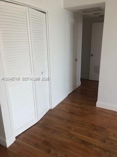 A hallway features white louvered closet doors, white walls, and wood-look flooring — 1000 West Ave # 1427, Miami Beach FL 33139, MIAMI BEACH, FL