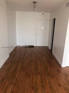 An empty room with white walls and wood-look flooring features a single white entry door — 1000 West Ave # 1427, Miami Beach FL 33139, MIAMI BEACH, FL