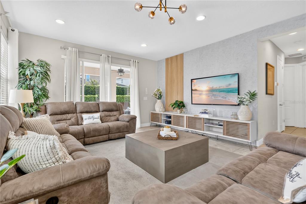 A living room features brown reclining sofas, a square coffee table, and a media console — 7657 WILMINGTON LOOP, KISSIMMEE, FL