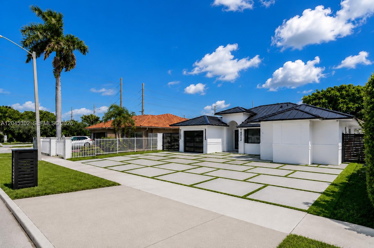 A modern white house with a black metal roof features a large paved driveway — 14712 SW 176th Ter, Miami FL 33187, MIAMI, FL