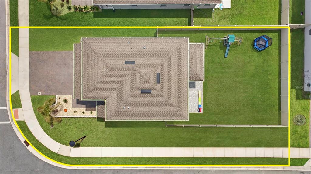 An aerial view shows a single-family home with a fenced backyard, playground, and driveway — 381 CRESTWIND DRIVE, DAYTONA BEACH, FL