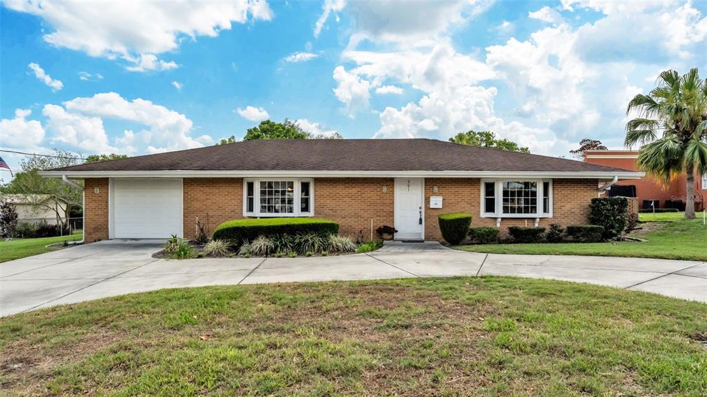A single-story brick house features a white garage door, a front door, and two windows — 901 WOODWARD STREET, LAKELAND, FL